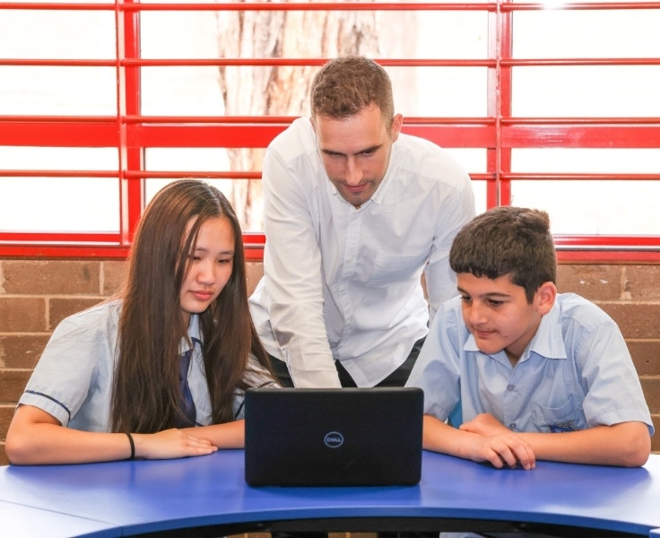 A teacher helping students with their work