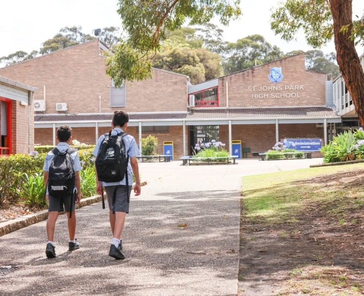 Two students walking into the school