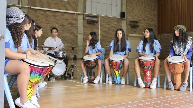 Students playing the drums with Evan Yako